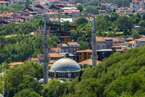 Eyüp Sultan Mosque surrounded by lush greenery and residential rooftops in Istanbul, historic Ottoman landmark.