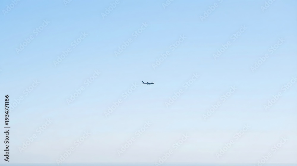 Fototapeta premium A small airplane flies solo in a clear blue sky with soft white clouds.