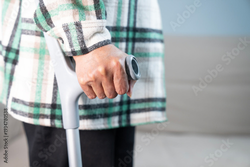 Close up of senior person holding walking cane at home. retirement and healthcare concept