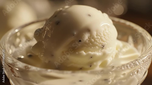 Close up of creamy ice cream in glass bowl with white pour