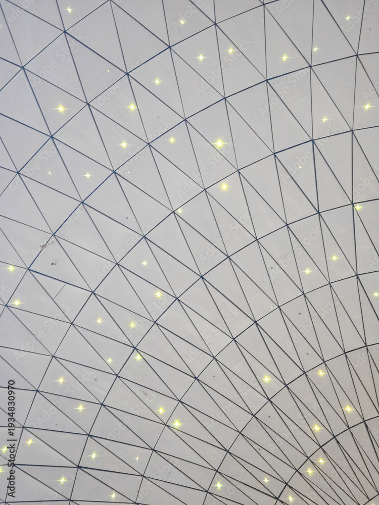 Fototapeta premium Geometric white ceiling grid with triangles and star-like lights