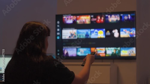 Woman browsing streaming apps on smart tv with remote