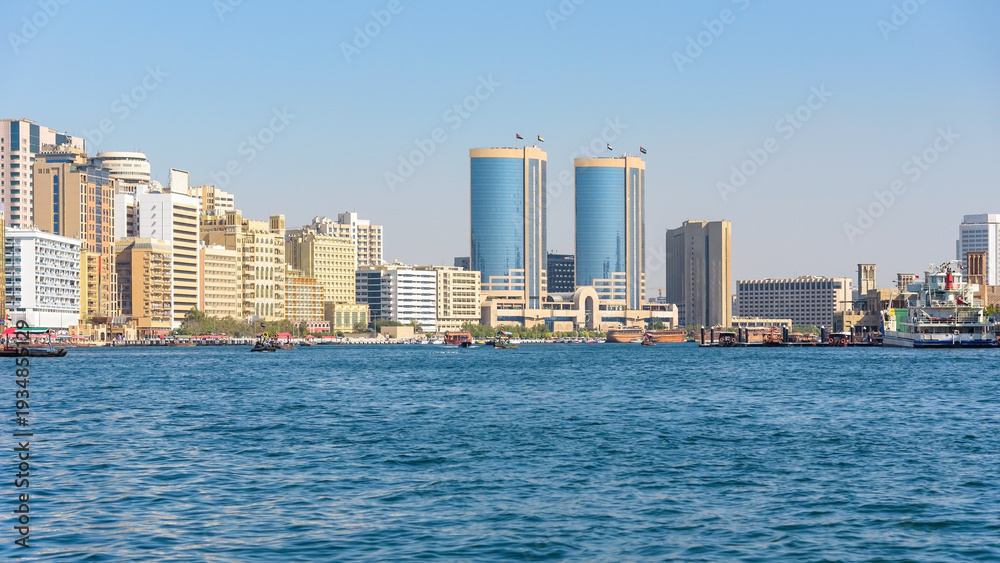 Fototapeta premium Modern skyline of Dubai Creek with traditional boats in the UAE