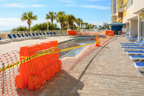 Tablou pe pânză An emptied out, closed for service resort swimming pool  under maintenance surrounded by safety barriers and mesh along the Grand Strand Atlantic Ocean at Myrtle Beach, South Carolina