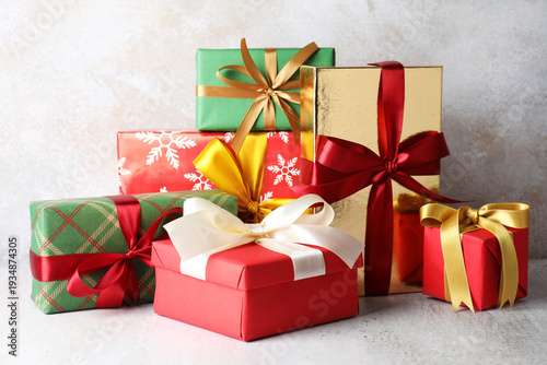 Many decorated Christmas gifts on light background, closeup