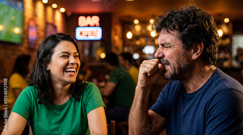Couple reacting to sports game in bar