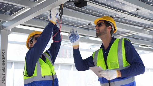 Professional technicians team working with digital tablet at solar power station for renewable energy, Engineers inspecting solar panel maintenance and electrical system check on rooftop