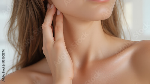 Woman gently touching neck and chest skin. Close detail showing anti-aging skincare routine, neck massage care, and relaxed self treatment for smooth rejuvenated decollete area.