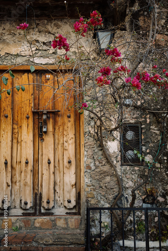 Rustic stone house with wooden door and bougainvillea in a traditional Mexican village