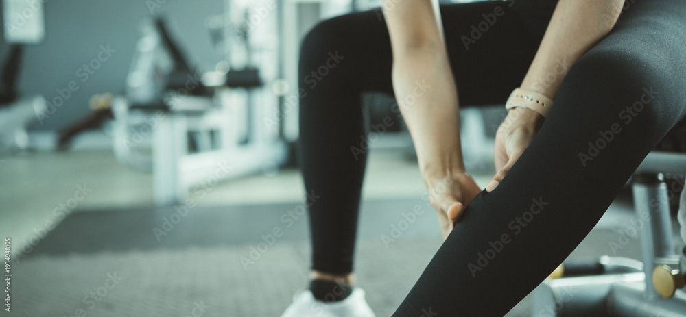 Obraz premium Female athlete experiencing repetitive strain injury in lower leg after intense gym workout, highlighting overuse syndrome, muscle fatigue and physical therapy recovery in active fitness lifestyle.