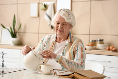 Senior woman pouring tea at...