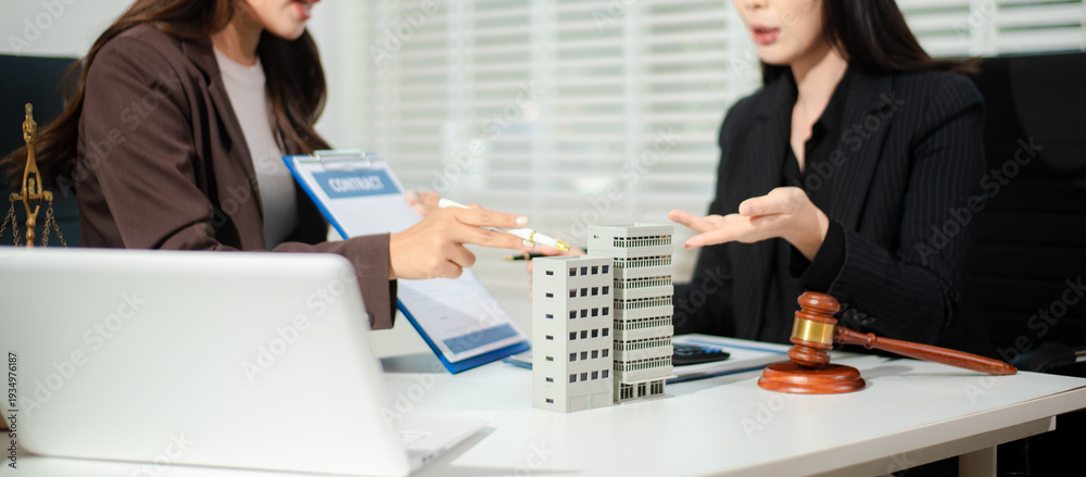 Fototapeta premium Real estate lawyer reviewing property contract with building model and gavel, concept of investment agreement, mortgage consultation, legal compliance