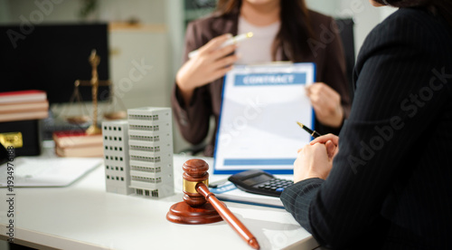 Real estate lawyer reviewing property contract with building model and gavel, concept of investment agreement, mortgage consultation, legal compliance
