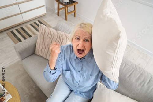 Senior woman with pillow on...