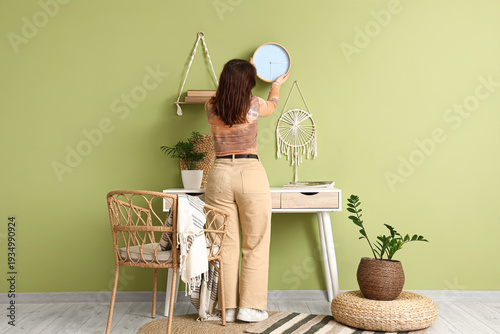 Young woman hanging clock o...