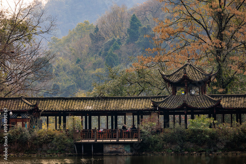 Traditional chinese walkway pavilion spanning serene water in china