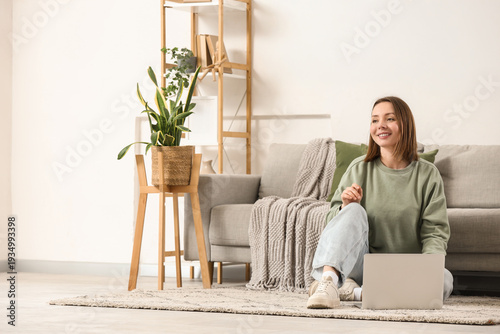 Happy young woman using lap...