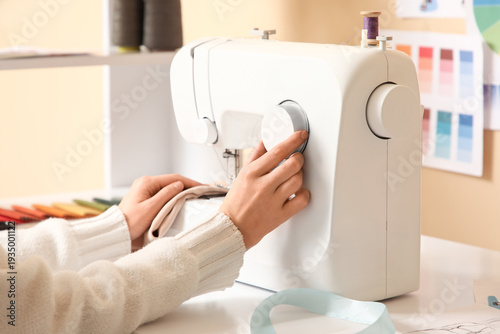 Female hands using sewing m...