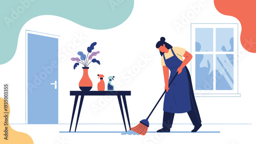 Woman wearing an apron sweeping the floor with a broom in a minimalist room with a table, vase, and spray bottles.