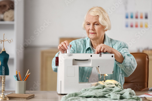 Senior female tailor using ...