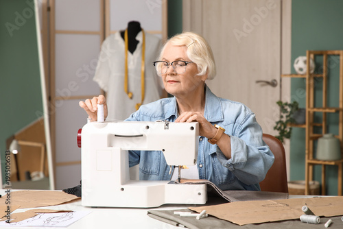 Senior female tailor using ...