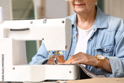 Senior female tailor sewing...