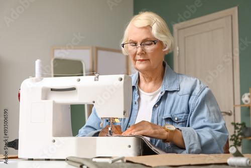 Senior female tailor sewing...