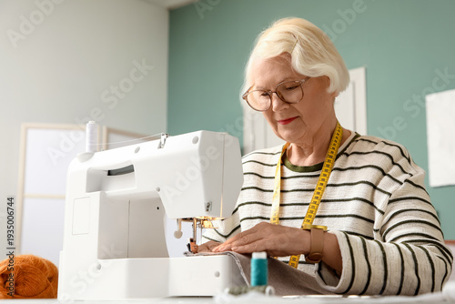 Senior female tailor sewing...