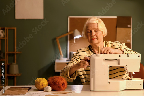 Senior female tailor using ...
