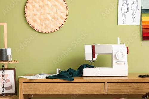 Obraz na plátne Tailor's workplace with sewing machine near green wall in atelier
