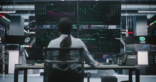 Focused Asian Woman Trader Leans Over Digital Tablet Verify Financial Data While Sitting in Front of Four Large Monitors. Concept of Cross Platform Analysis and Meticulous Precision in Stock Exchange.