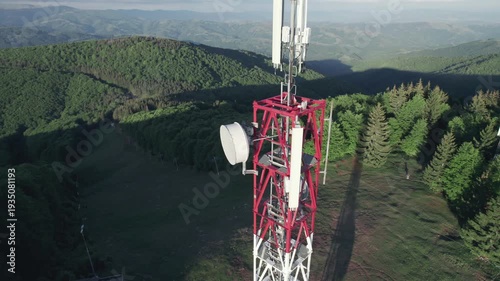 Telecommunication tower with cellular antennas for 5g mobile internet network on forest and blue sky background