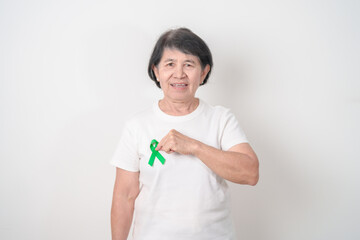 Elderly with Green Ribbon for concept of April Donate Life month, Organ Donation and Transplant Awareness, May Mental Health Awareness month and October Liver cancer. Health and world cancer day