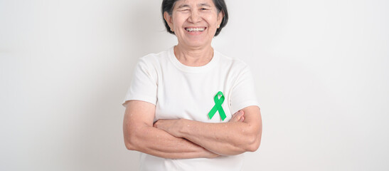 Elderly with Green Ribbon for concept of April Donate Life month, Organ Donation and Transplant Awareness, May Mental Health Awareness month and October Liver cancer. Health and world cancer day