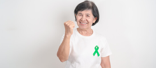 Elderly with Green Ribbon for concept of April Donate Life month, Organ Donation and Transplant Awareness, May Mental Health Awareness month and October Liver cancer. Health and world cancer day