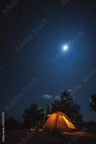 nature traveling with orange camping tent on mountain with milky way and star background