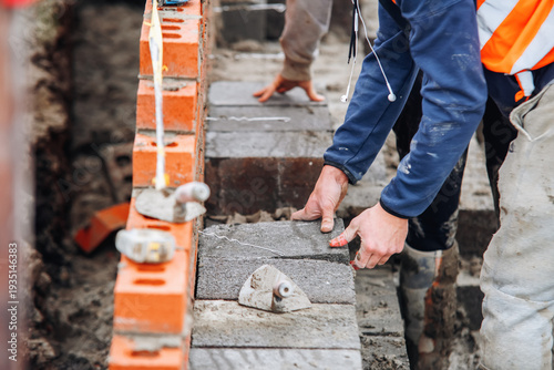 Photos Construction worker laying concrete blocks on building site