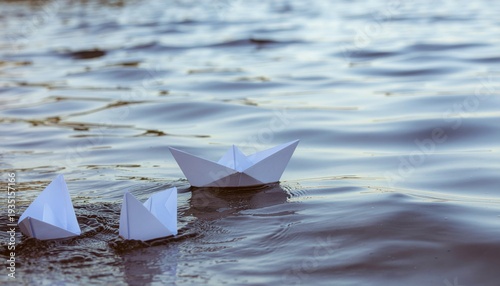 Paper Boat Sailing Away From A Group Of Identical  