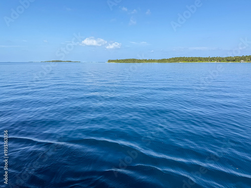 Photos Beautiful deep blue sea water surface with a small distant island on the horizon under a clear sky