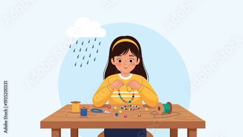 Creative young girl sits at a wooden table making a colorful bead necklace as a rainy cloud floats above her, representing an indoor hobby.