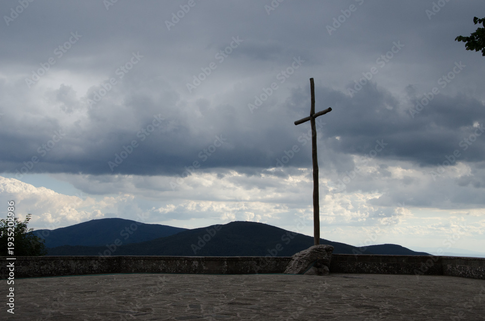 Obraz premium Simple Wooden Cross on Hilltop Against Stormy Sky