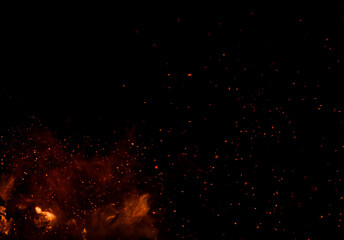 The black background shows fire in the foreground, surrounded by numerous sparks.