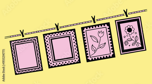 A line of framed artwork, including floral designs and decorative borders, are displayed like laundry on a clothesline against a yellow background, suggesting a craft or art exhibition