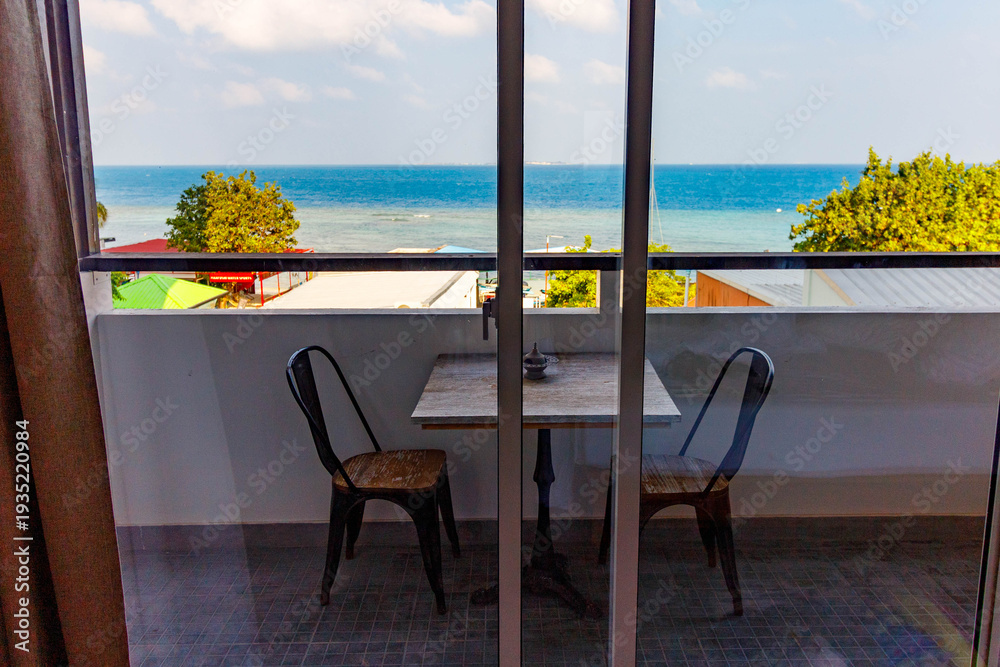 Fototapeta premium Sunlit balcony overlooks turquoise sea