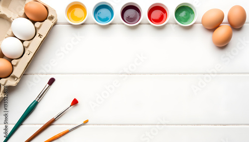 Top view of egg decorating kit with paintbrushes and colorful dyes, Easter creativity