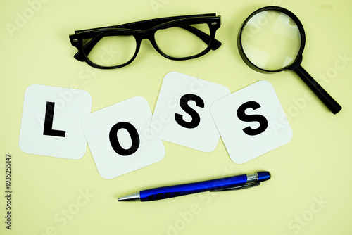 Fotografía LOSS alphabet letters with magnifying glass, eye glasses and pen on yellow backg