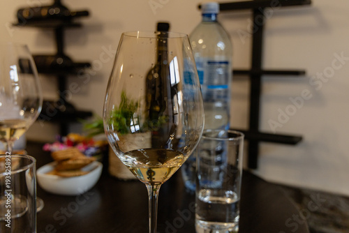 Bilde på lerret Empty Wineglass Closeup Beside Water Bottle