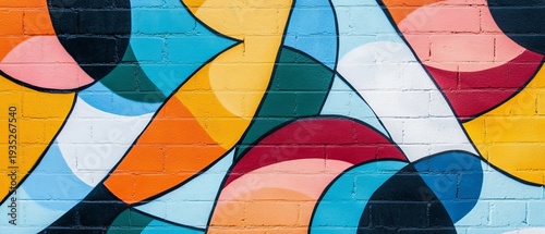 Colorful abstract mural with curved shapes and vibrant hues on a brick wall surface