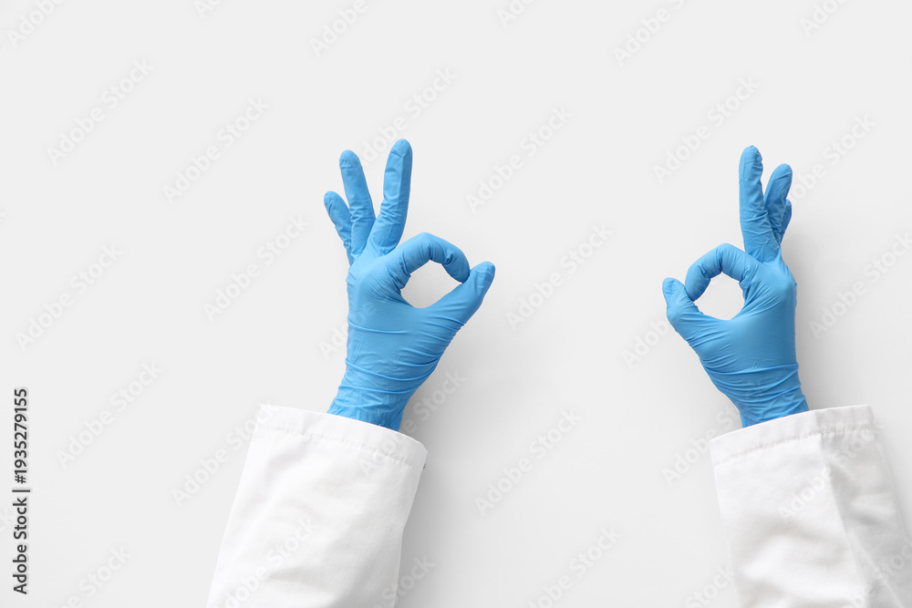 Obraz premium Female doctor's hands showing OK on white background