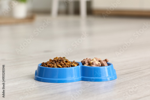 Photos Feeding bowls with dry pet food in kitchen